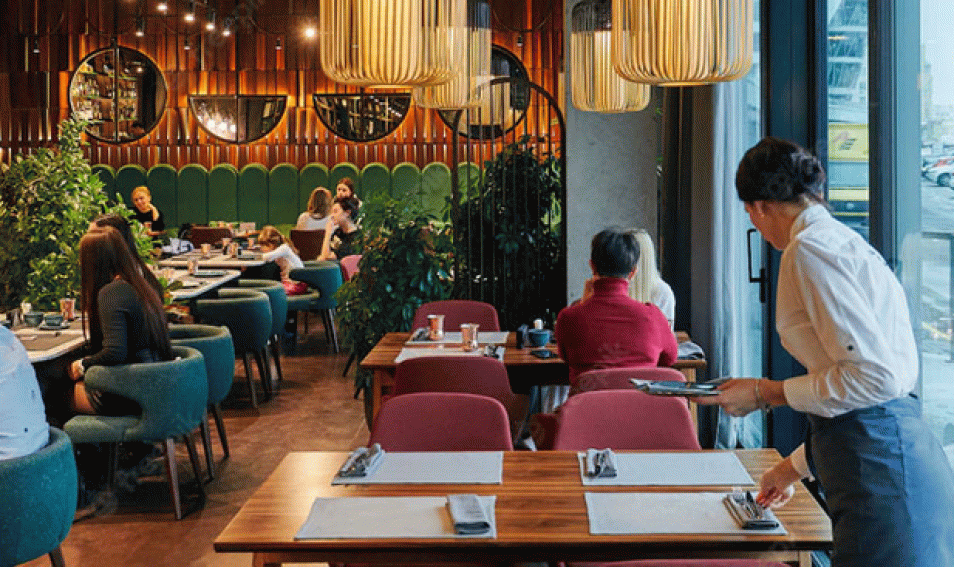 Cozy Restaurant With People and Waiter